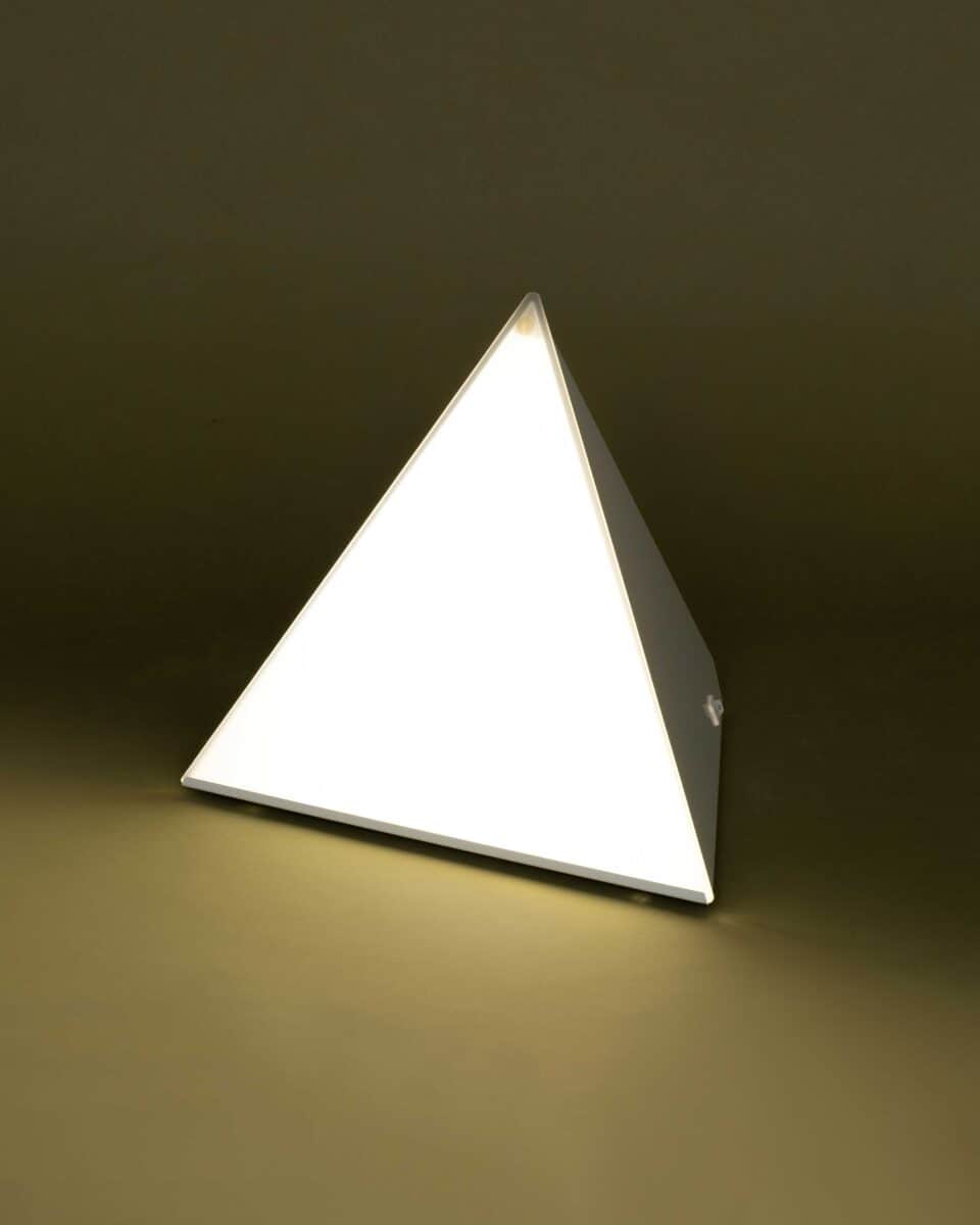 Luxor lamp lit on an olive background